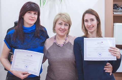 Выпускницы курса закройщика с документами об обучении и своими первыми изделиями.